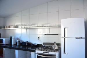 福塔莱萨波隆戈迪旅馆的白色的厨房配有炉灶和冰箱。