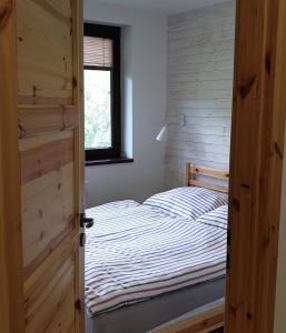 Vysoke Tatry - Horny SmokovecApartment No.35的一间卧室配有一张床和一扇木门