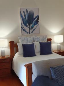 马莱尼The Paddocks的一间卧室配有一张带蓝色和白色枕头的床