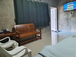 南邦Baanrimdoi Resort Lampang的客房设有床、长凳和电视。