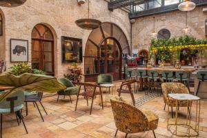 耶路撒冷阿莱格拉精品酒店的一间带桌椅的餐厅和一间酒吧