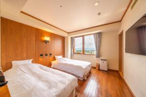带广北海道酒店的酒店客房设有两张床和一台平面电视。