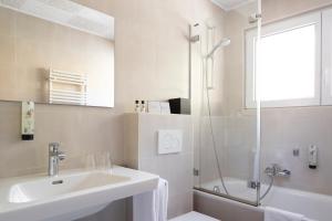 韦尔比耶圆厅酒店的白色的浴室设有水槽和淋浴。