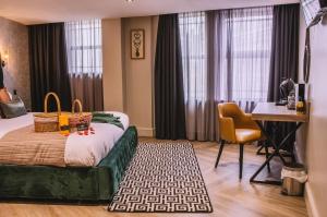 斯旺西格兰德酒店的酒店客房配有一张床铺、一张桌子和一张书桌。