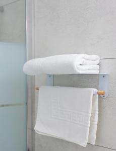 普瓦捷马克床酒店的浴室内带白色毛巾的毛巾架