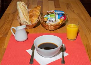 普瓦捷马克床酒店的桌子,上面放着咖啡,面包和果汁