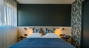 波尔多Live Hotels Bordeaux Lac的一间卧室设有一张大床和绿色的墙壁