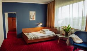 普热梅希尔信天翁酒店的一间卧室设有一张床和蓝色的墙壁