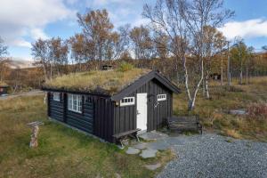 MaurvangenBesseggen Fjellpark AS的黑白的建筑,有草屋顶