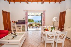 派莱卡斯Corfu Resorts Villas的一间带桌椅的客厅和一间用餐室
