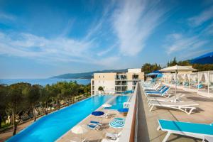 拉巴克Girandella Valamar Collection Resort的酒店游泳池设有躺椅,享有海景。