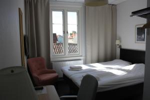 格兰纳格拉纳花园酒店的卧室配有床、椅子和窗户。