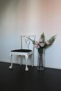 格兰纳格拉纳花园酒店的椅子旁的白色椅子和花瓶
