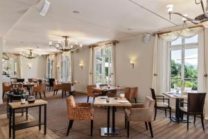 日内瓦Hôtel Résidence Parc des Eaux Vives的餐厅设有桌椅和窗户。
