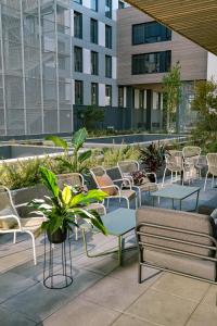 波尔多Live Hotels Bordeaux Lac的一个带桌椅的庭院和建筑