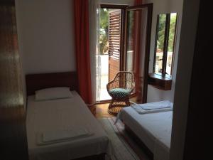 圣内德尔贾B&B Pansion Jure Matijević的客房设有两张床、一把椅子和窗户。