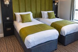法纳姆霍格巴克Spa酒店的绿墙旅馆客房的两张床