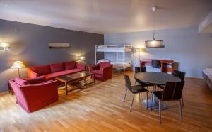 哈尔斯塔F2 Hotel的客厅配有红色的沙发和桌子