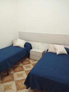 蒙德罗Appartamento a Mondello的配有两张床铺的蓝色床单和枕头