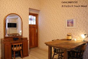 美瑛町カフェロッジ Touch Wood的客房设有木桌和镜子。
