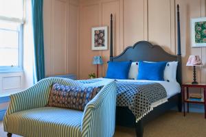 泰晤士河畔金斯顿The Mitre, Hampton Court的一间卧室配有一张带椅子和沙发的床