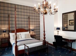 杜塞尔多夫温莎酒店的一间卧室配有一张床、一张书桌和一面镜子