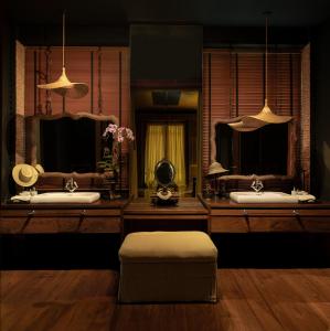 清迈Chandra Residence的浴室设有2个带镜子的盥洗盆和凳子
