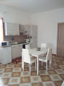 蒙德罗Appartamento a Mondello的白色的厨房配有白色的桌子和椅子