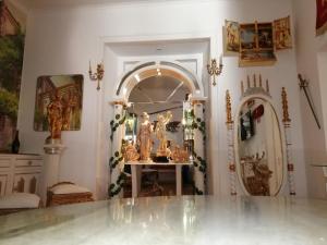 贝雅Império Romano Guest House的一间设有镜子和一张带雕像的桌子的房间