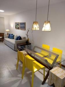 伊塔卡雷Village Angelim的客厅配有玻璃桌和黄色椅子