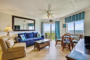 塔维涅Oceanside Retreat的客厅配有蓝色的沙发、桌子和椅子