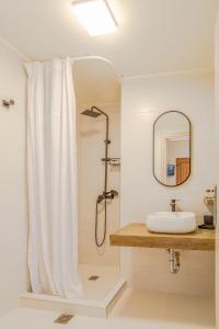 里姆尼奥纳斯Αlissachne Suites的浴室配有淋浴帘和盥洗盆。
