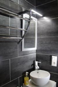 帕特里莫尼奥Chambre d'hôtes à 5mn des plages的浴室设有白色水槽和镜子
