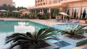 加德满都珠峰酒店的一座建筑前的游泳池,两棵棕榈树