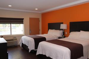 好莱坞柯蒂斯汽车旅馆的橙色墙壁的酒店客房内的两张床