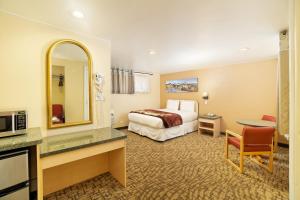格伦伍德温泉格伦伍德斯普林斯旅馆的酒店客房,配有床和镜子