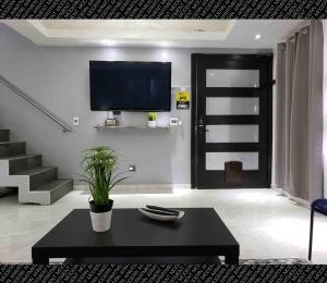 罗萨里托The Condo (by Modern Apartments)的客厅配有电视和黑咖啡桌。