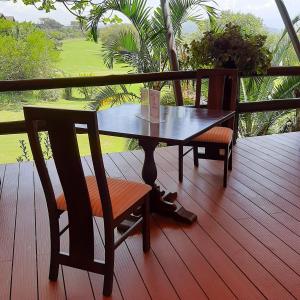 奈瓦沙Ol-Kine Cottage at The Great Rift Valley Lodge & Golf Resort Naivasha的观景甲板上的木桌和椅子