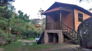 克鲁赛罗Sítio Serra do Gigante的一个小房子,设有门廊和木楼梯