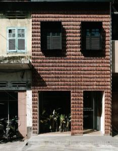 棉兰Semalam at Sun Yat Sen - SELF CHECK IN的砖砌的建筑,有两扇窗户,有植物