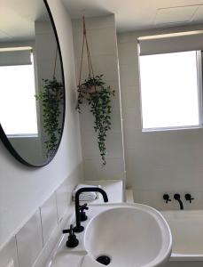 黄金海岸乐滩公寓的浴室配有盥洗盆、镜子和浴缸