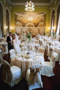莫纳汉维斯特纳阿姆斯酒店的宴会厅里的新娘和新郎,配有白色桌子
