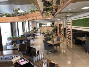 亚罗钦Hotel - Restauracja "SŁONECZNA"的一间设有桌椅的餐厅,种植了植物