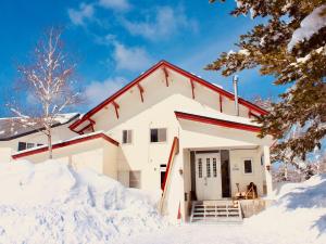 八幡平市安匹艺术之色山林小屋的雪中的房子,周围积雪