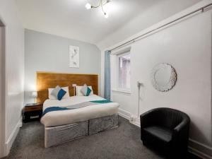 若泽斯OYO Eastbank Hotel, Speyside Scotland的一间卧室配有一张床和一把椅子