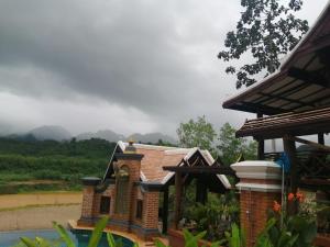 琅勃拉邦Chateau Orientale Resort的房屋前有雕像的小建筑