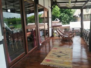 琅勃拉邦Chateau Orientale Resort的门廊设有玻璃门、桌子和椅子