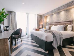 斯旺西格兰德酒店的酒店客房设有一张大床和一张书桌。