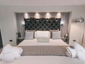 斯旺西格兰德酒店的一间卧室配有一张大床和大床头板