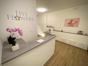 的里雅斯特Five Flowers Guest House - self check-in的墙上有花的柜台的商店